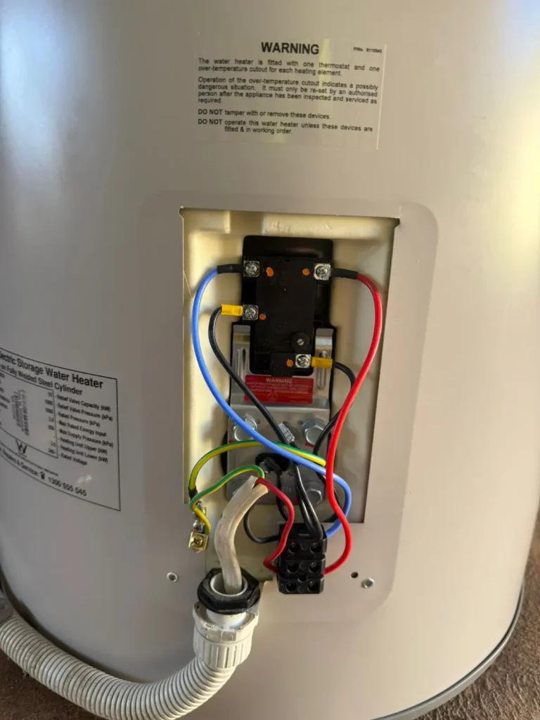 Detailed view of the internal electrical wiring and thermostat installation for an electric hot water plumber adelaide by Citywide Plumbing in Adelaide.