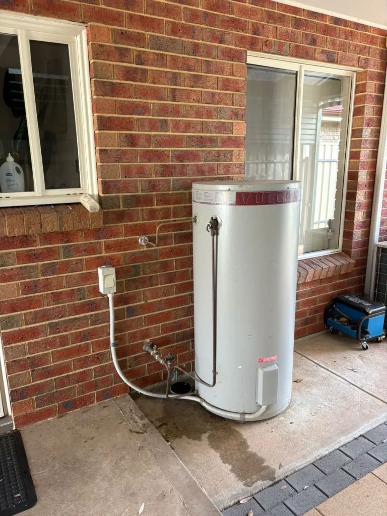 Expert hot water repairs Adelaide: Citywide Plumbing technician inspecting and servicing the internal thermostat and heating element of an electric water heater.